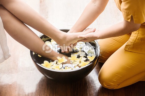 Foot treatment in bowl of flowers